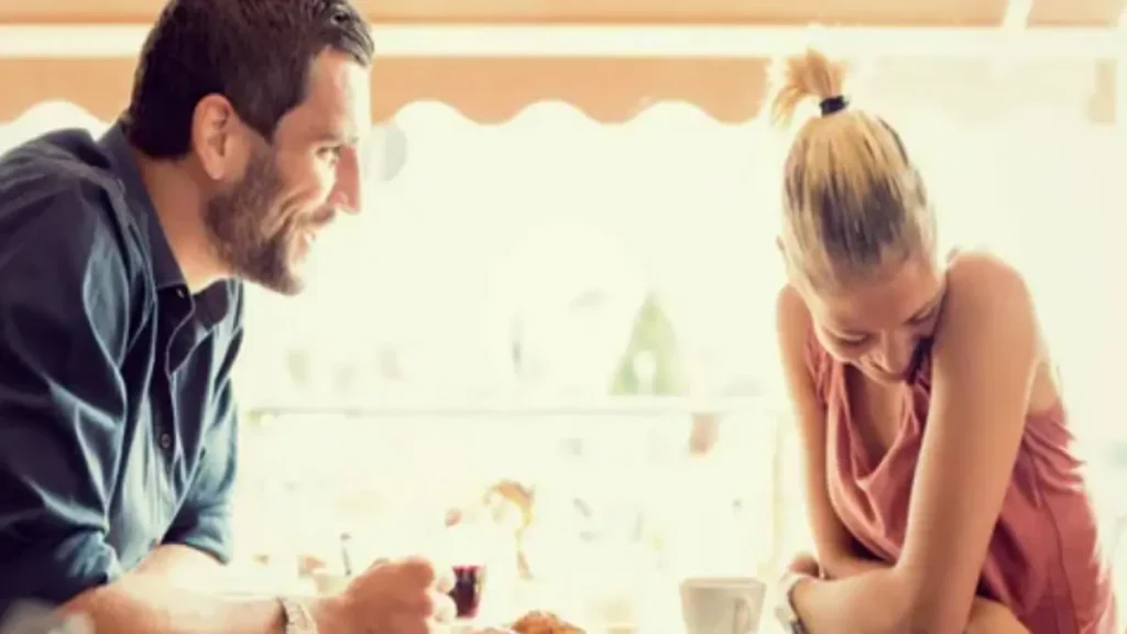 A confident man talking to a beautiful girl in a bar escaping awkwardness